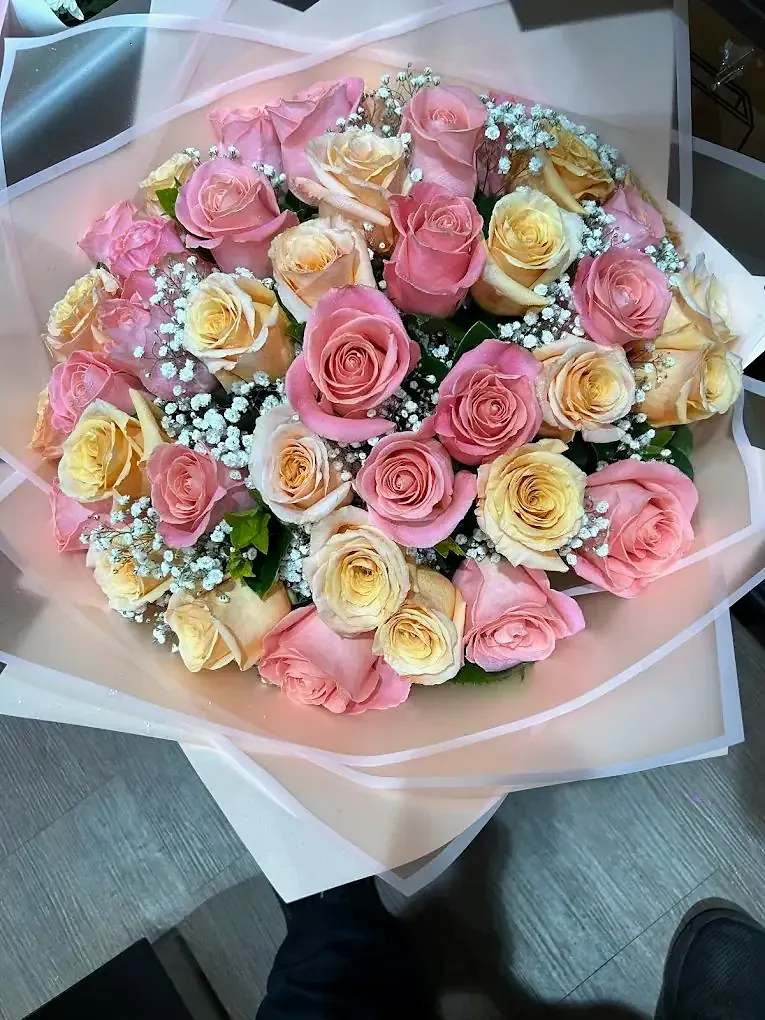 Peach and pink roses with baby's breath in blush wrapping